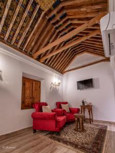 a living room with red furniture and wooden ceilings at Riad Dar Chama in Chefchaouen