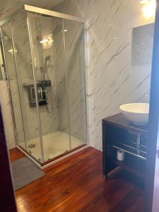 a bathroom with a glass shower and a sink at Quinta do Esquilo - Hotel Rural in Rendufe +24 photos