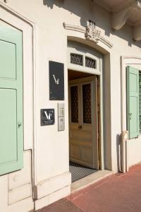 una puerta delantera de un edificio blanco con puertas verdes en VILLA FLEURY - APPART'HÔTEL DE STANDING en Limoges
