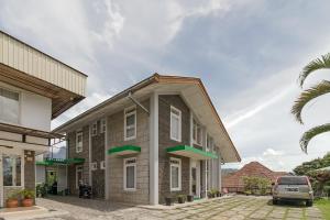 una casa con tetto spiovente con un'auto parcheggiata fuori di RedDoorz near Jam Gadang Syariah Bukit Tinggi a Bukittinggi