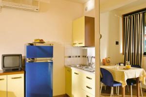a small kitchen with a blue refrigerator and a table at Camping Village Le Capanne in Marina di Bibbona
