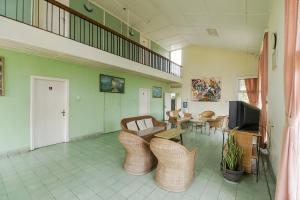 a living room with wicker chairs and a tv at RedDoorz near Jam Gadang Syariah Bukit Tinggi in Bukittinggi
