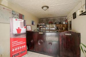 a restaurant with a bar and a counter in a room at RedDoorz near Jam Gadang Syariah Bukit Tinggi in Bukittinggi