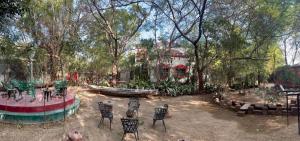 a garden with chairs and a boat in a park at Sharad Baug homestay in Bhuj