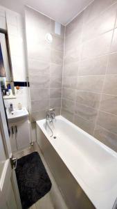 a bathroom with a bath tub and a sink at Central London Spacious Flat with 2 to 3 Bedrooms in London