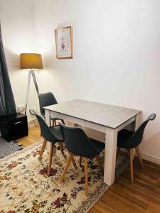 a dining room table with four chairs and a lamp at Central London Spacious Flat with 2 to 3 Bedrooms in London
