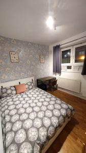a bedroom with a large bed and a table at Central London Spacious Flat with 2 to 3 Bedrooms in London