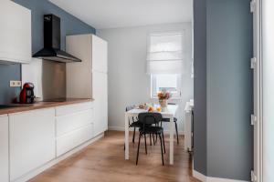 uma cozinha com uma mesa branca e cadeiras em Evere EU Residence em Bruxelas