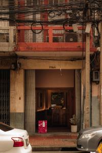 an entrance to a building with cars parked in front at Cozy Room at The Coffee Store Charoenkrung in Bangkok