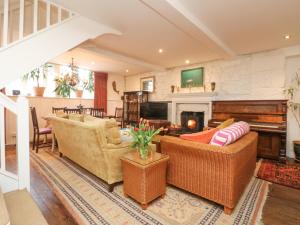 una sala de estar con 2 sofás y un piano en Roncon's Villa, en Penzance