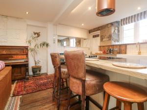 una cocina con encimera y algunos taburetes en Roncon's Villa, en Penzance