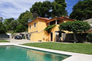 a house with a swimming pool in front of a house at Villa 282 in Ponte de Lima