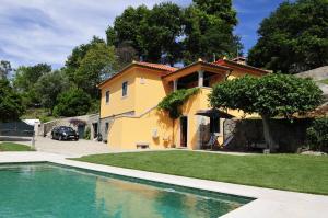 a house with a swimming pool in front of a house at Villa 282 in Calheiros