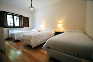 a bedroom with two beds and two lamps and a window at Villa 282 in Calheiros