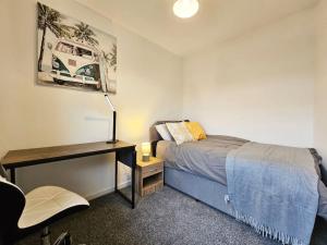 um quarto com uma cama, uma secretária e uma cadeira em Little Hulton, Manchester 
