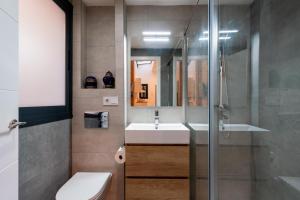 La salle de bains est pourvue d'un lavabo et d'une douche en verre. dans l'établissement Veoapartment Relator Patio, à Séville