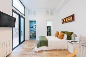 a bedroom with a bed and a flat screen tv at Veoapartment Relator Patio in Seville