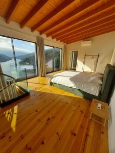 a bedroom with a bed in a room with large windows at Quinta Vale do Cabo in Riba Douro