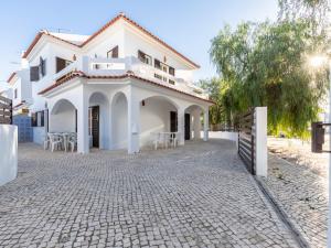 a white house with tables and chairs in a driveway at Akivillas Manta Rota Ocean in Manta Rota