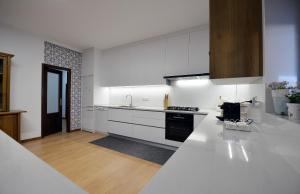 eine Küche mit weißen Schränken und einer weißen Arbeitsplatte in der Unterkunft Villa 281 in Esposende
