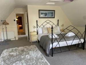 um quarto com uma cama e um quarto com uma escada em Cottages at Woodlands, Dormer em Wareham