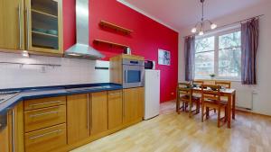una cucina con pareti rosse e un tavolo con sedie di Apartmán Esser 4 a Milovice
