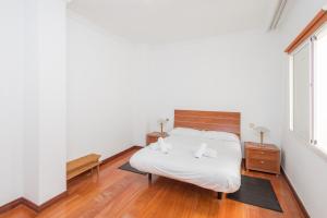 1 dormitorio con cama blanca y ventana en Gravina House 2BR - 2 min to Las Canteras Beach, en Las Palmas de Gran Canaria