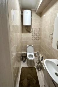 a small bathroom with a toilet and a sink at Двухкомнатная элитка Золотой Квадрат in Bishkek