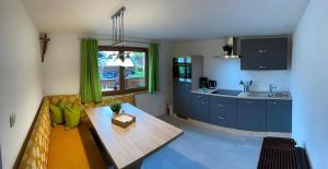ein Wohnzimmer mit einem Tisch und einer Küche in der Unterkunft Ferienwohnung Dornau in Langkampfen