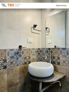 a bathroom with a white sink and a mirror at The Baga Domingo-TBV in Baga