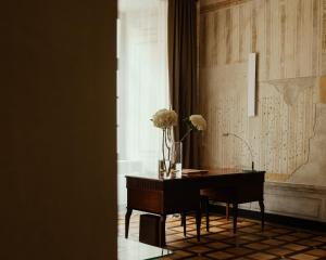 a room with a desk and a vase with flowers on it at Hotel Pod Różą in Krakow