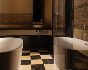 a bathroom with a tub and a checkered floor at Hotel Pod Różą in Kraków