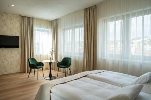 a bedroom with a bed and a table and chairs at Hotel Tatra in Bratislava