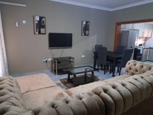 uma sala de estar com um sofá e uma mesa em Edmut Apartments em Lusaka