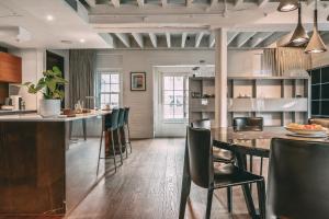 a kitchen with a bar with chairs and a table at Immaculate 2-Bed Loft Apartment In Central London in London