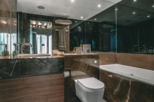a bathroom with a toilet and a tub and a sink at Immaculate 2-Bed Loft Apartment In Central London in London