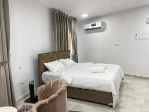 Habitación de hotel con cama y silla en استراحة الشرف ALSHARAF, en Al ‘Aqar