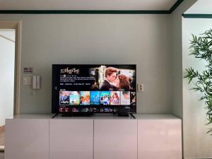 a flat screen tv sitting on top of a cabinet at Sunnyside House/ Hongik St. Exite 5~7 3min in Seoul