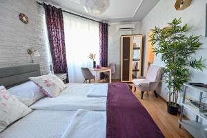 een kleine slaapkamer met een bed en een bureau bij BellaVista 2 Apartman in Eger