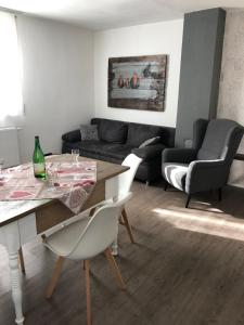 een woonkamer met een tafel en een bank bij Ferienwohnung mit WiFi und 2 Schlafzimmern - b45533 in Ipsheim
