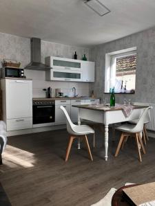 een keuken met een tafel en twee stoelen en een tafel en een aanrecht bij Ferienwohnung mit WiFi und 2 Schlafzimmern - b45533 in Ipsheim