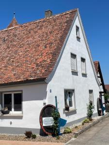 une maison blanche avec un toit rouge dans l'établissement Ferienwohnung mit WiFi und 2 Schlafzimmern - b45533, à Ipsheim