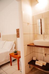 a bathroom with a sink and a bed and a mirror at Espaço Fateixa in Jericoacoara