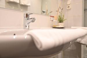 a white bathroom sink with a faucet at Land-gut Hotel zum Löwen Garni in Marktheidenfeld