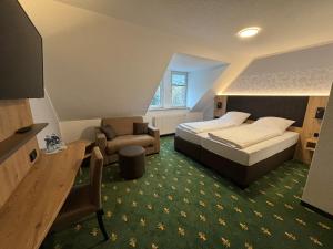 a bedroom with a bed and a desk and a chair at Hotel Gasthof zur Heinzebank in Wolkenstein
