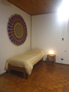 1 dormitorio con 1 cama y reloj en la pared en Verde Parra en Godoy Cruz