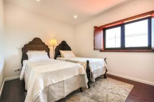 a bedroom with two beds and a window at Villa 278 in Varziela