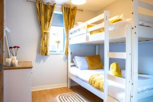 1 dormitorio con literas y cortinas amarillas en Newly furnished Appartment near Train Station wolverhampton en Wolverhampton