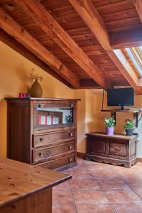 a living room with a large wooden dresser and a tv at Casa Rural Fuente del Arca Montejo in Montejo de la Sierra