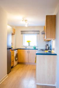 a kitchen with wooden cabinets and a counter top at Newly furnished Appartment near Train Station wolverhampton in Wolverhampton